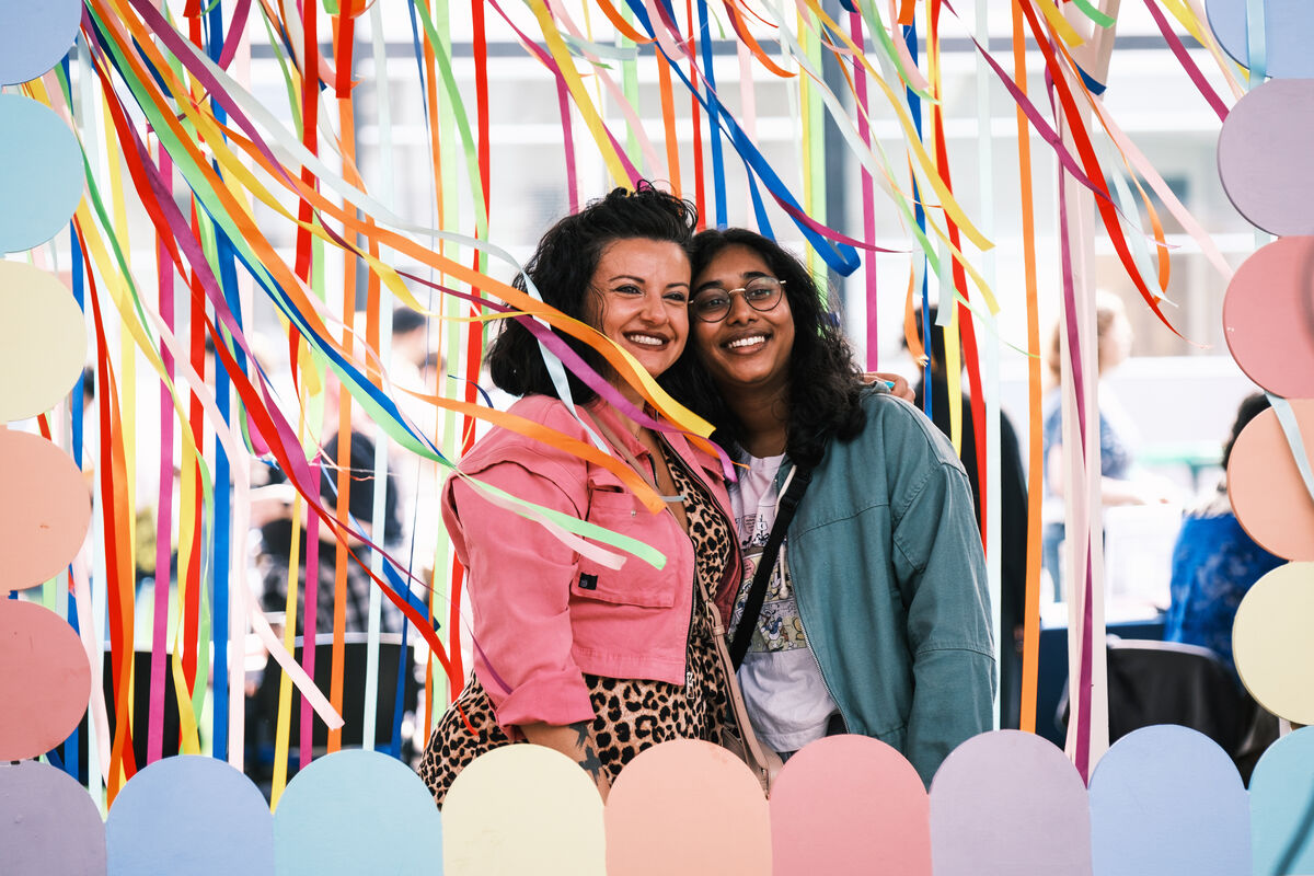 Students posing for a photo with some colourful streamers at the Freshers' Fair